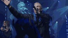 a man singing into a microphone while a woman sings in front of him