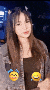 a woman wearing a denim jacket and a black tank top has a smiley face with the words ha ha on it