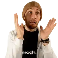 a man wearing a beanie and a white jacket with the word mcdh on it