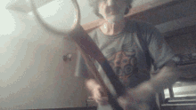 a man in a t-shirt with a skull on it holds a tennis racquet