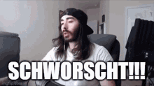 a man with long hair and a beard is sitting in a chair with the words schworscht !!! above him .