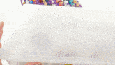 a person 's hand is reaching into a plastic container full of lego bricks