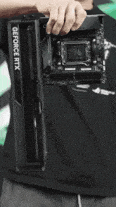 a man is holding up a motherboard that says rog on it