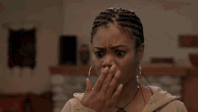 a woman is standing in a kitchen with her mouth open and a surprised look on her face .