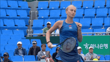 a woman wearing a blue shirt that says npl is running in a stadium