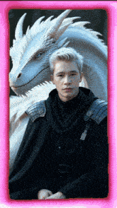 a man in a black cape stands next to a white dragon in a pink frame