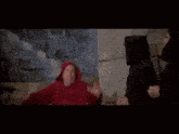 a man in a red robe is standing next to a man in a black robe