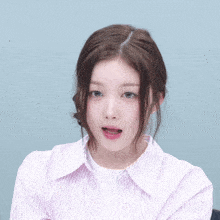 a woman wearing a pink and white striped shirt is making a surprised face
