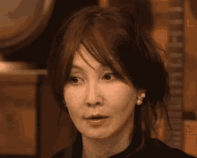 a close up of a woman 's face with her mouth open and earrings .