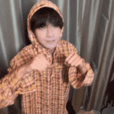 a person wearing a plaid shirt and a hood