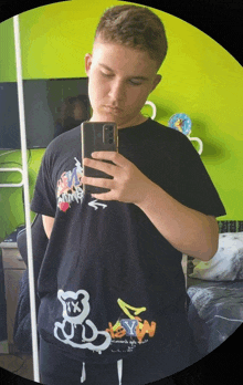 a young man taking a selfie in front of a green wall