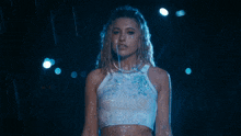 a woman is covered in blue paint and has her hands on her chest