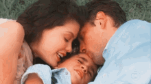 a man and a woman kissing a child on the forehead