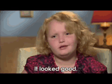 a little girl sitting in a chair with the words it looked good behind her