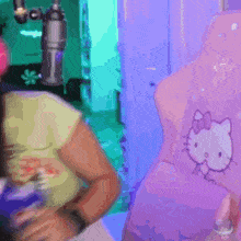 a person is sitting in a chair with a hello kitty pillow on it