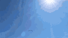 the sun shines brightly in the blue sky above a flock of birds