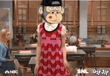 a girl with a monkey mask on her head is standing in a classroom