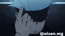a man with blue hair is covering his face with his hand