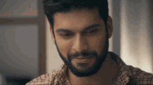 a man with a beard is smiling and looking down