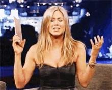 a woman in a strapless black dress is holding a piece of paper