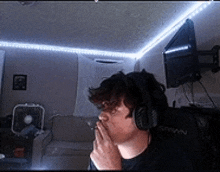 a man wearing headphones smoking a cigarette in a living room .
