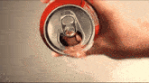 a person is opening a coke can with a label that says " natural flavor "