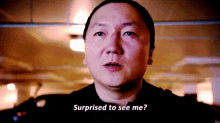 a man is surprised to see me while standing in a dark room .