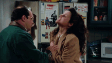 a man and a woman are fighting in front of a refrigerator with a news magazine on it