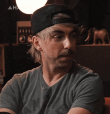 a man wearing a hat and a t-shirt that says ' nm ' on it
