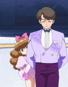 a man in a purple suit is standing next to a girl in a pink leotard