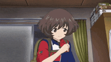 a girl in a red shirt is holding a remote in her hand