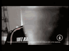 a man is standing in front of a computer screen with the words trail blac on it .