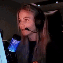 a woman wearing headphones and a microphone is smiling