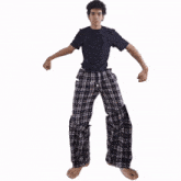 a young man wearing plaid pajama pants and a black shirt is dancing