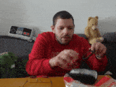 a man wearing a red sweater with the word nes on the front