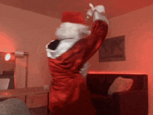 a person dressed in a santa suit is dancing in a living room