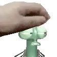 a hand is holding a squidward from spongebob squarepants .