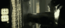 a blurry picture of a person standing in front of a wall with a clock on it .