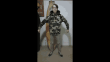 a man wearing a king hoodie stands in front of a surfboard