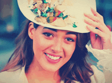 a woman wearing a white top hat with flowers on it