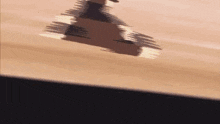 a skateboarder is doing a trick on a wooden floor .