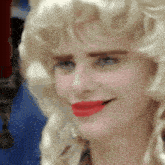 a woman with blonde hair and red lipstick is smiling .