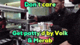 two men in black gloves are working in a kitchen with a sign that says do n't care