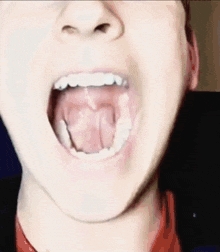 a close up of a man 's mouth with his tongue hanging out