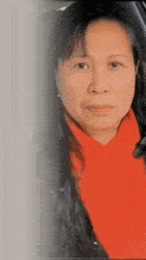 a woman wearing a red scarf and earrings looks at the camera
