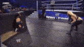 two women are wrestling in a ring with a w logo on the back