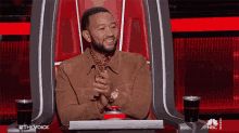a man sitting in a chair with a nbc logo on the bottom