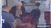 a man with a mustache is sitting at a table in a restaurant with other men .