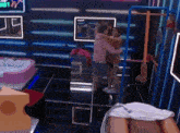 a man in a pink hoodie is hugging another man in a room with a bathtub