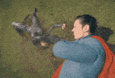 a man in a superman costume stands on a field
